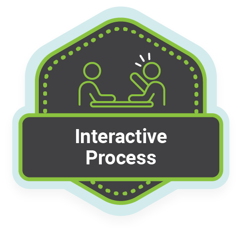 Una forma de hexágono negro con borde verde claro. En el centro hay un icono de dos personas sentadas en una mesa, con una de ellas hablando. Una pancarta en la parte inferior dice "Proceso interactivo".